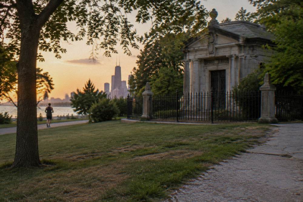 A quiet Lincoln Park path at dusk with bare trees and distant streetlights