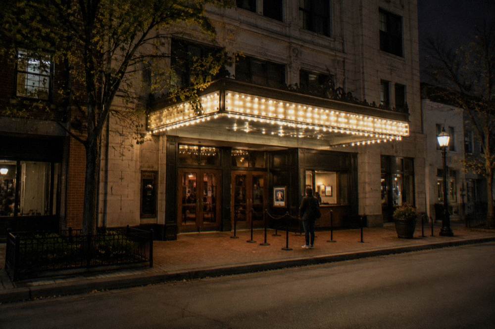 Historic Chicago theater facade at night with a lit marquee and dark side street
