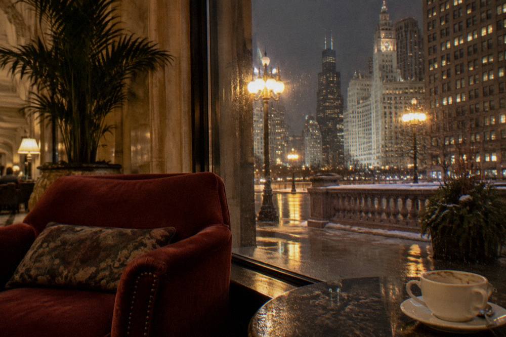 A red velvet armchair beside a tall window in a vintage hotel lounge