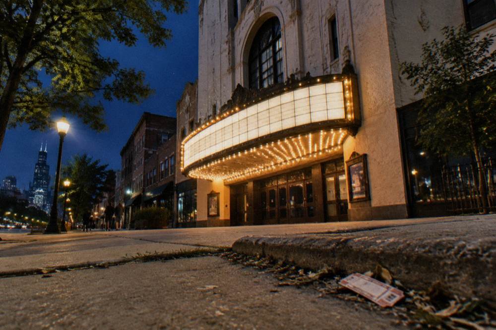 A historic Chicago theater facade at night with an illuminated marquee.