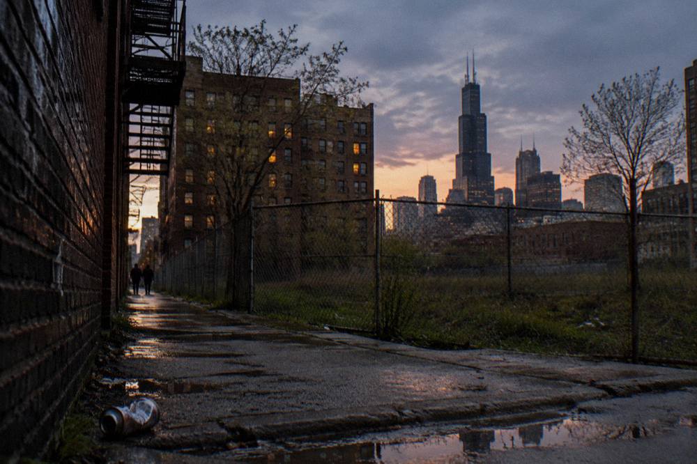 Dark alley in downtown Chicago at dusk with brick walls and fire escapes