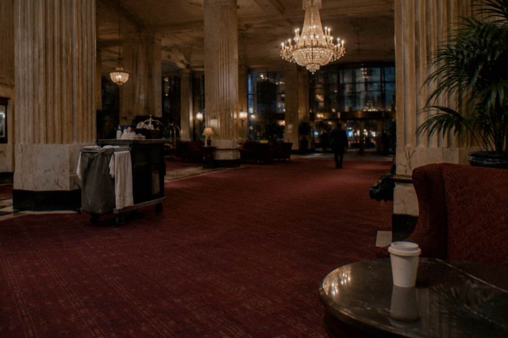 Grand historic hotel lobby with chandeliers and marble columns at night