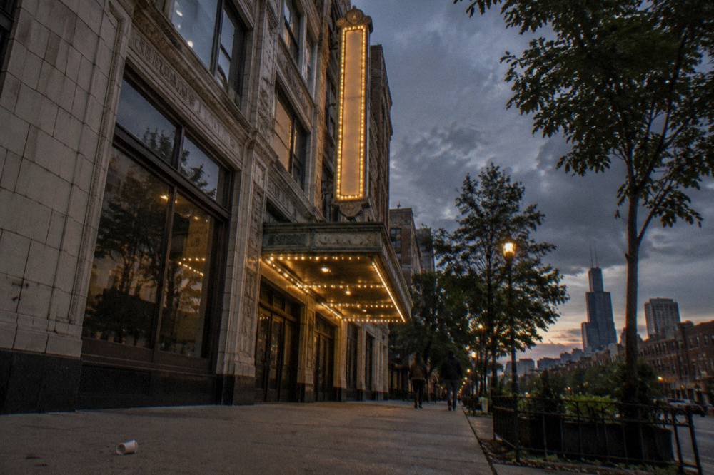 Vintage Chicago street corner at dusk with brick facades and a glowing marquee