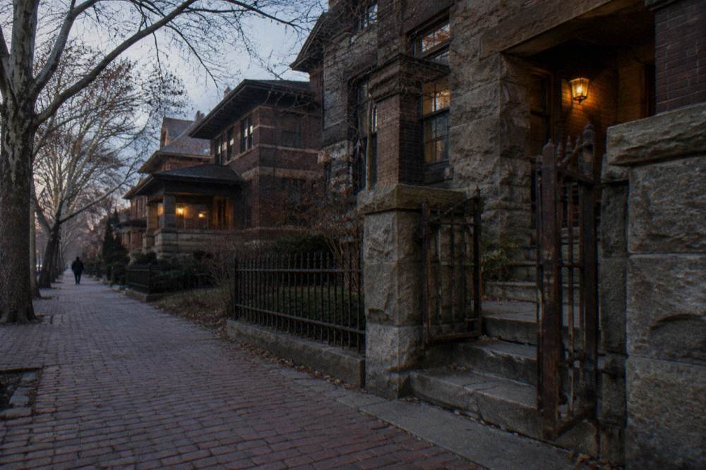 Gilded-age brick rowhouses on a dark Prairie Avenue street with bare trees