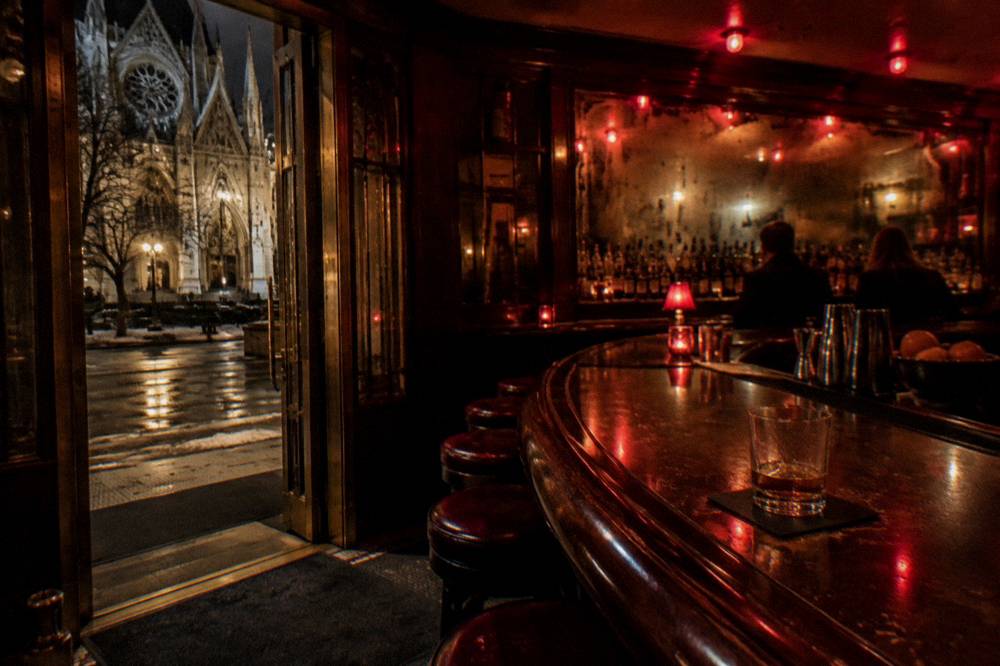 A historic Chicago bar interior with a long curved bar and dim red lighting