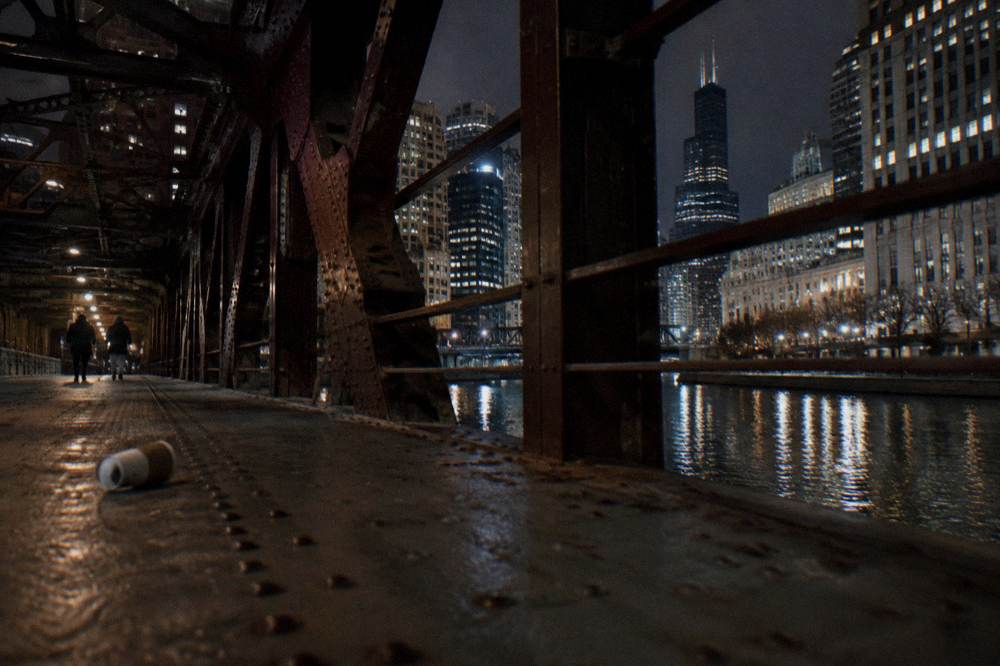 The Chicago River at night with downtown bridges and lit buildings reflected in the water