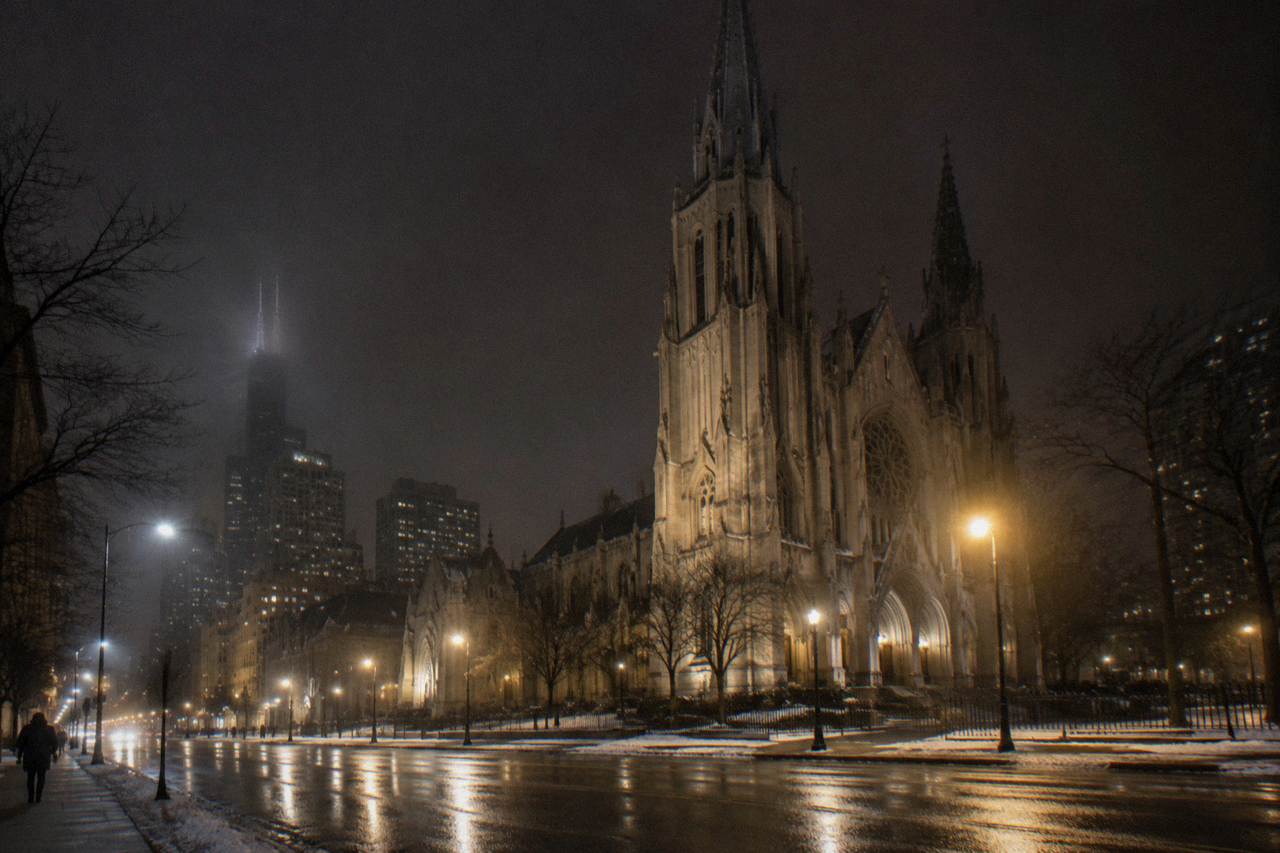 Holy Name Cathedral Gothic facade across State Street at night with fog under the streetlights