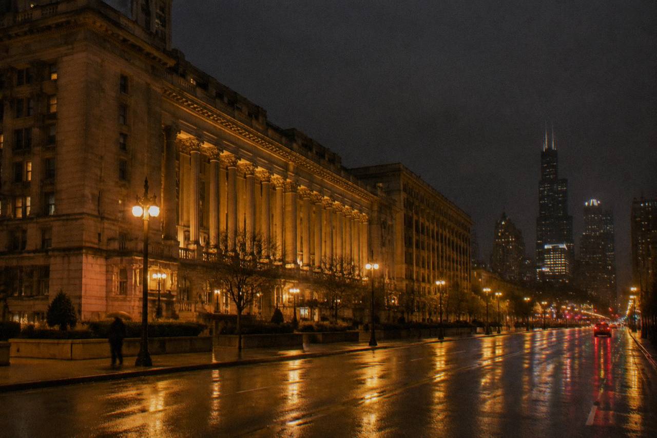 Congress Plaza Hotel colonnade glowing amber across a rain-slicked Michigan Avenue at night